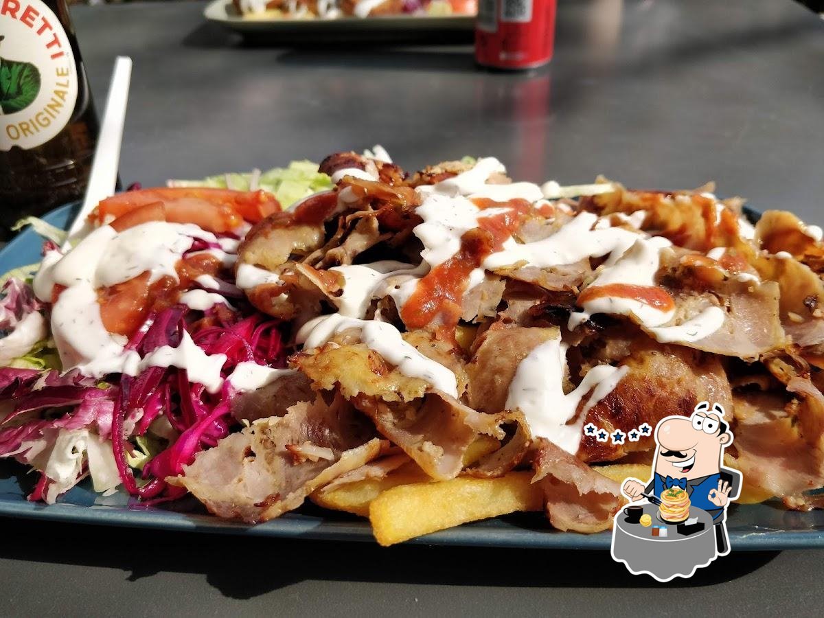 Carne di kebab con salse bianca e rossa, patatine, cavolo viola e pomodoro su piatto azzurro, Golden Moustache