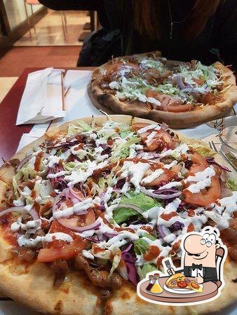 Due pizze kebab con carne, pomodoro, lattuga, cipolla rossa e salsa bianca su un tavolo di Golden Moustache